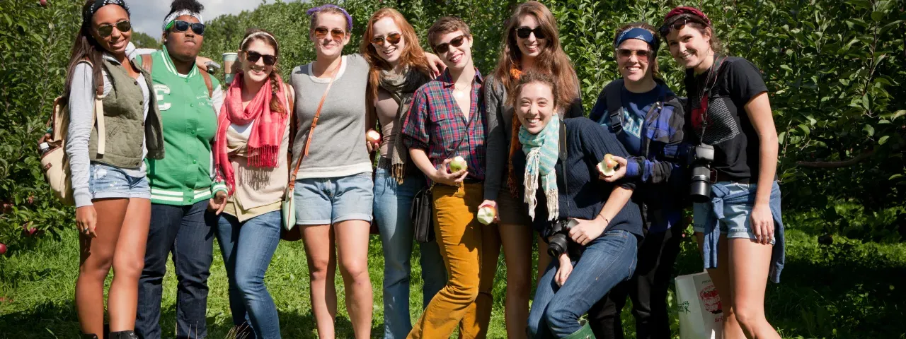 A group of students picking apples on Mountain Day.